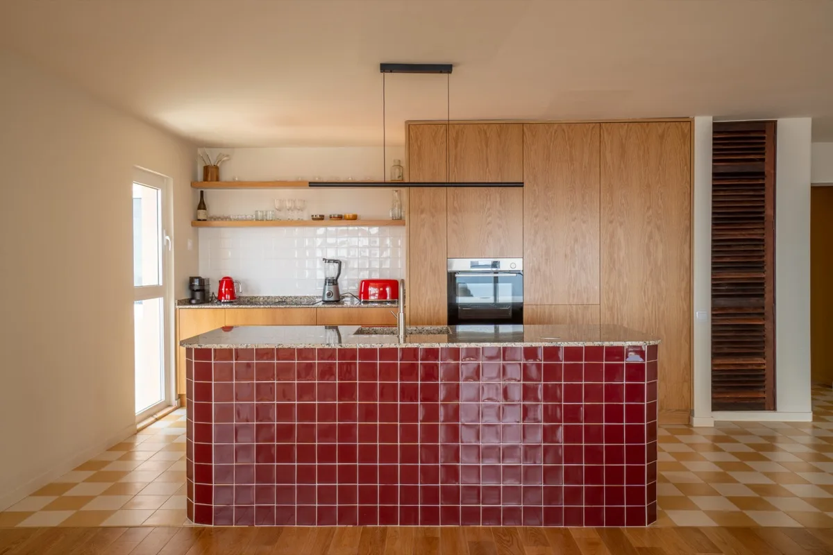 The kitchen and its oxblood-tiled island